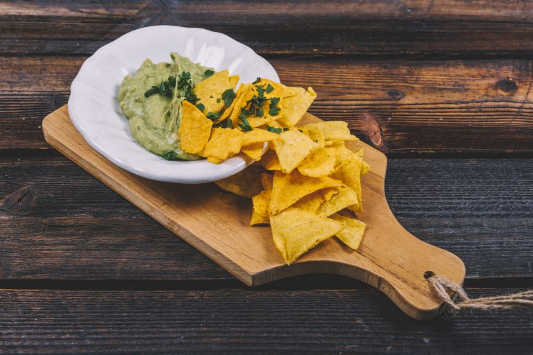guacamole-bowl-with-mexican-nachos-wooden-cutting-board